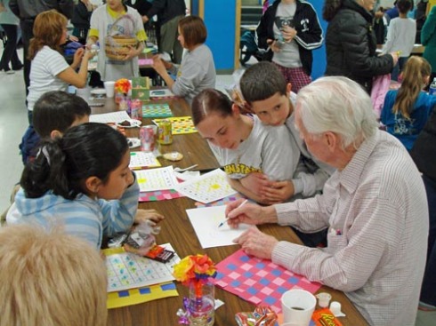 Even Start participants Bella Suna, Maribel Fonseca, and her son Jesmar Mangual during a game of Literacy Bingo with senior citizens at A.P. Morris Early Childhood Center on March 19.